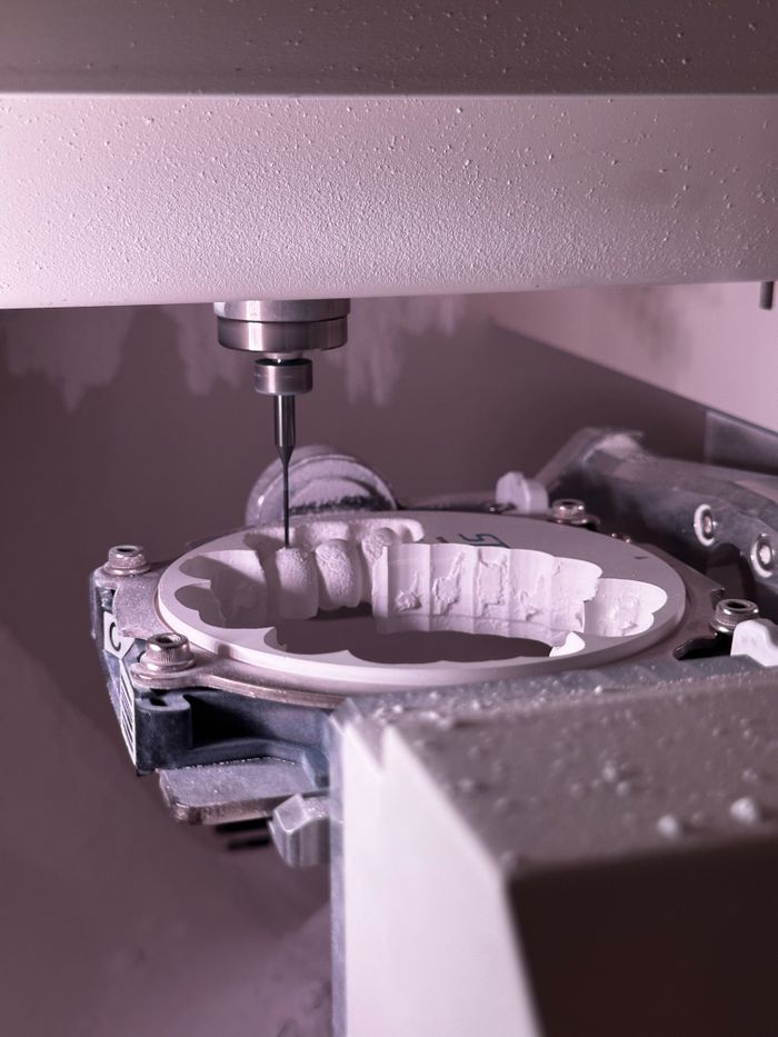 Detailed view of CNC grinding machine shaping ceramic material with precision tool.